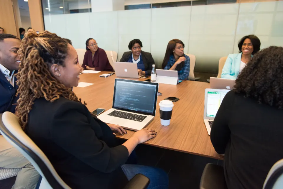 A finance team reviewing work together around a meeting table